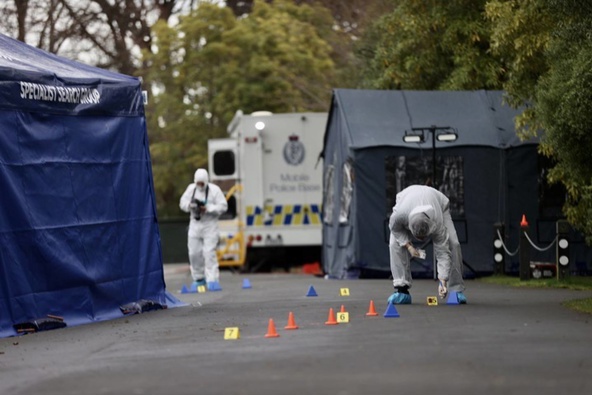 A Police forensic team comb an area for evidence at the Medbury Tce property. (Photo / George Heard)