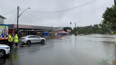 Rescue crews wait on Dawson Street near the intersection of Woodlark Street in Lismore after a person was swept into flood water. (Photo / news.com.au)