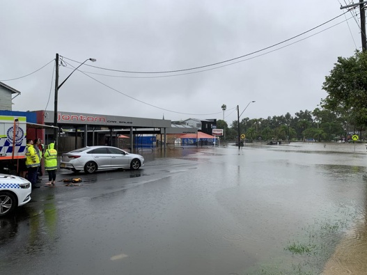 Rescue crews wait on Dawson Street near the intersection of Woodlark Street in Lismore after a person was swept into flood water. (Photo / news.com.au)