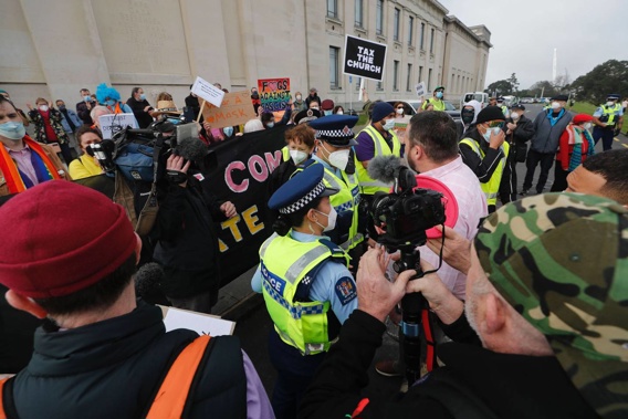 A pro-Freedom & Rights Coalition supporter was blocked by police in getting close to the counter-protest group at the Domain. (Photo / Dean Purcell)