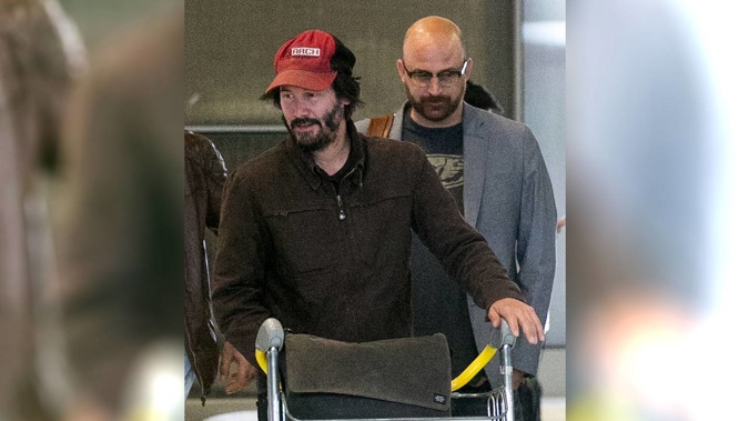 Keanu Reeves gives a masterclass in airport cool while waiting for luggage. (Photo / Getty Images, Marc Piasecki)
