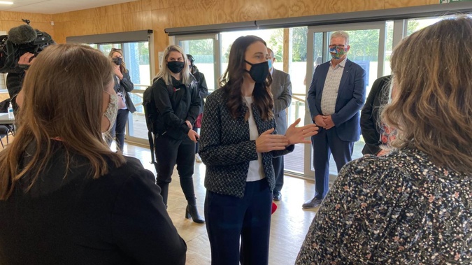 Prime Minister Jacinda Ardern chats with local health workers at a pop-up vaccination clinic at Eltham's Taumata Recreation Centre today. (Photo / Jamie Morton)