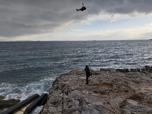 In this photo provided by the Greek Coast Guard, a helicopter searches over the Aegean Sea near the northwestern island of Lesbos, Greece, Tuesday, Feb. 7, 2023. Three migrants died and 16 were rescued off the Greek island of Lesbos Tuesday after a dinghy transporting them from the nearby coast of Turkey hit rocks in high winds, authorities said. (Greek Coast Guard via AP)