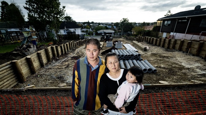 May Qiu and husband Hulin Young say they've lost privacy after the developers behind their property chopped down a 4m high hedge that separated their garden from the building site. Photo / Dean Purcell