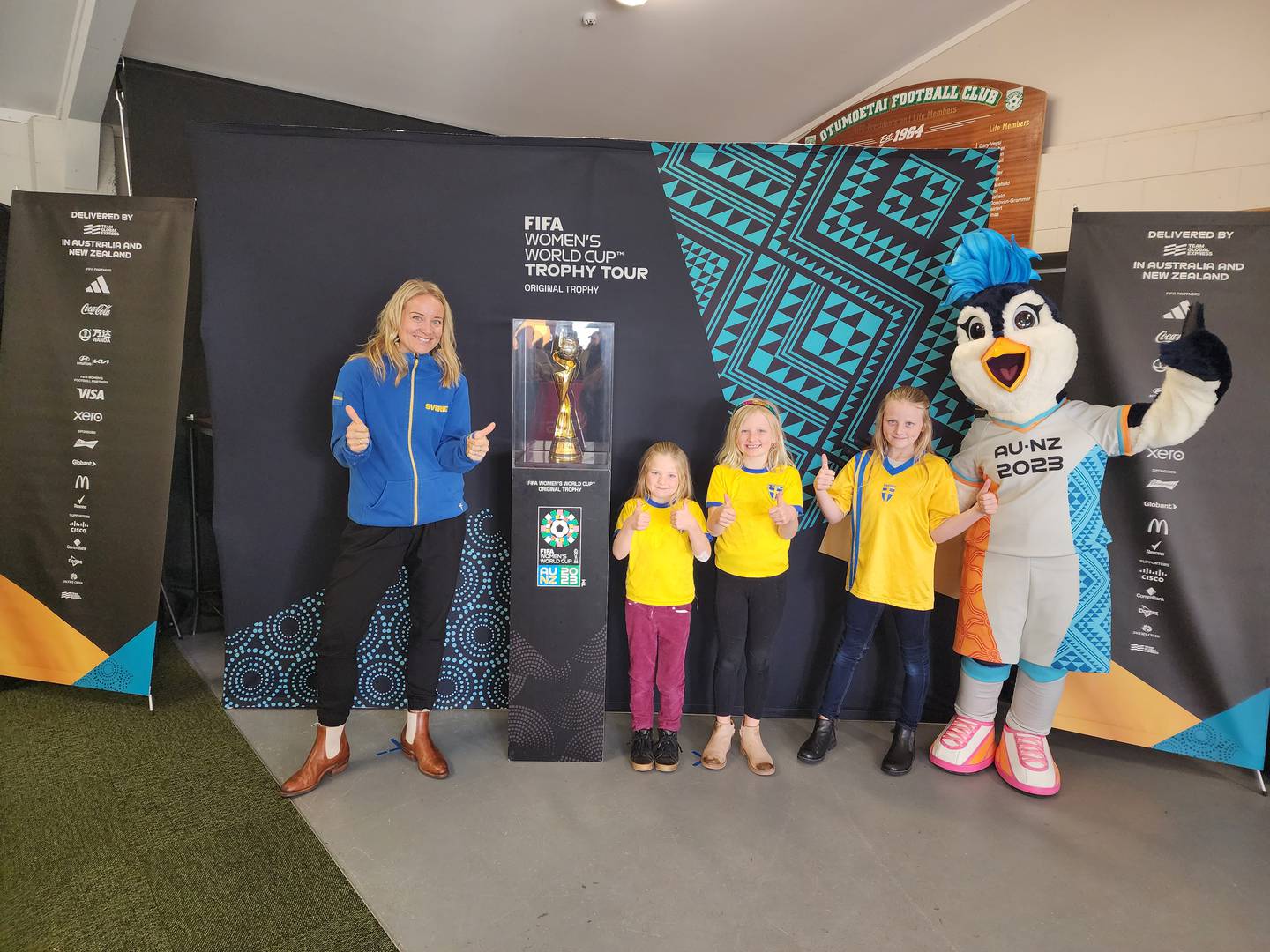 Tauranga resident Sofie Falk with her three daughters - Tuva Ware, 5, Linnea Ware, 7, and Eva Ware, 9, the Fifa Women’s World Cup trophy and tournament mascot Tazuni. Photo / Gavin Ogden