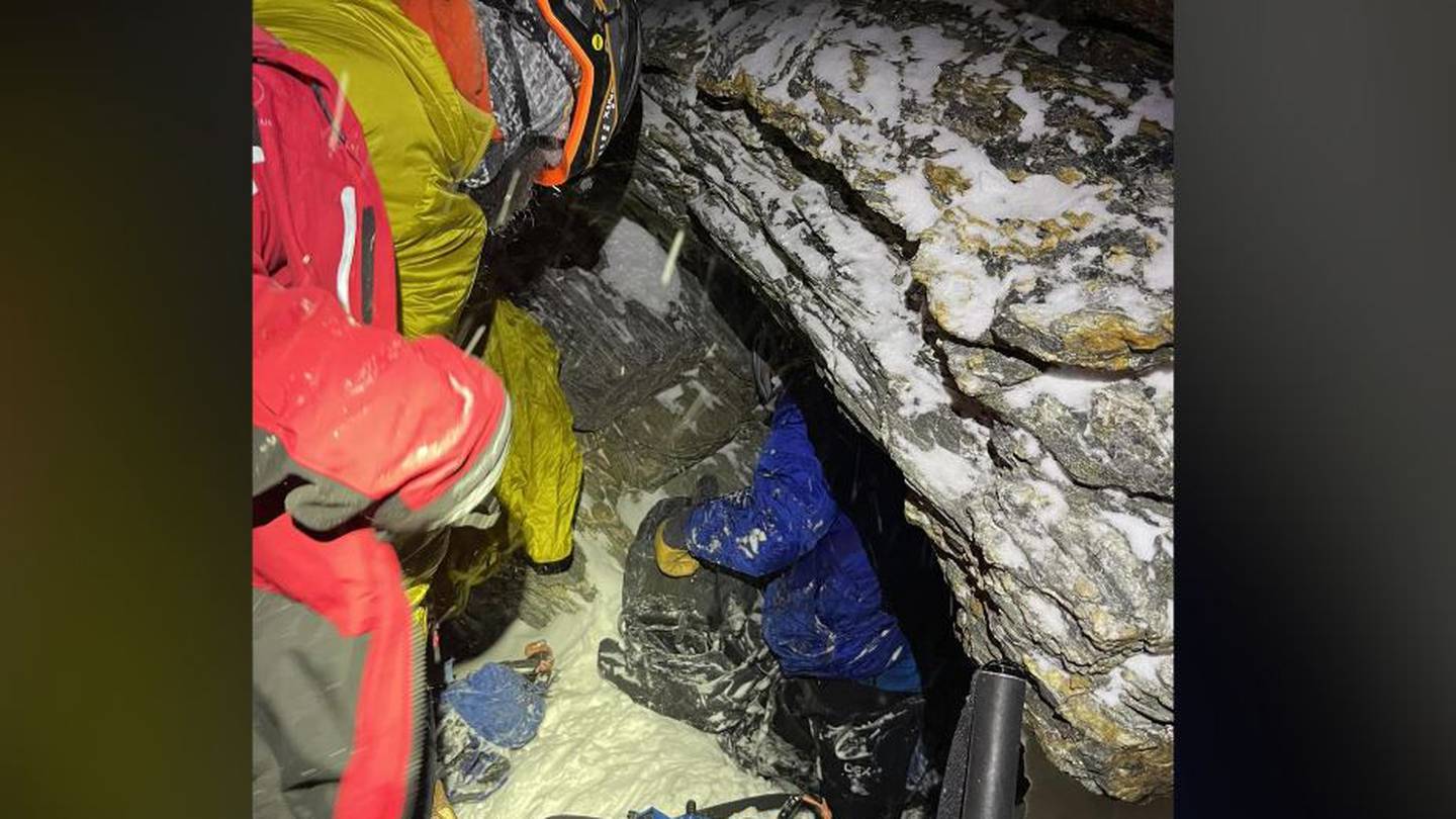 One of the stricken climbers, in blue, is finally reached by members of the Queenstown Alpine Cliff Rescue team. Photo / Queenstown Alpine Cliff Rescue Team
