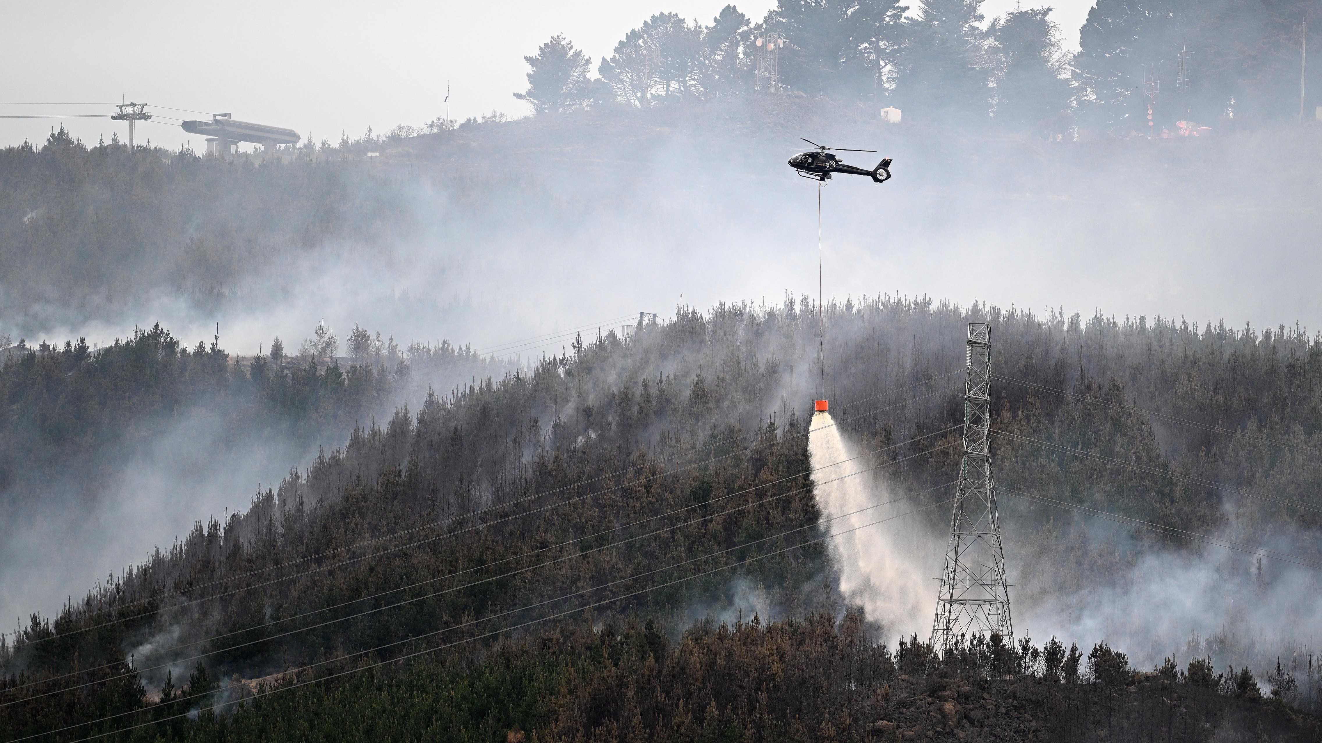 Helicopters work to extinguish the fire in Christchurch's Port Hills. Photo / Joe Allison