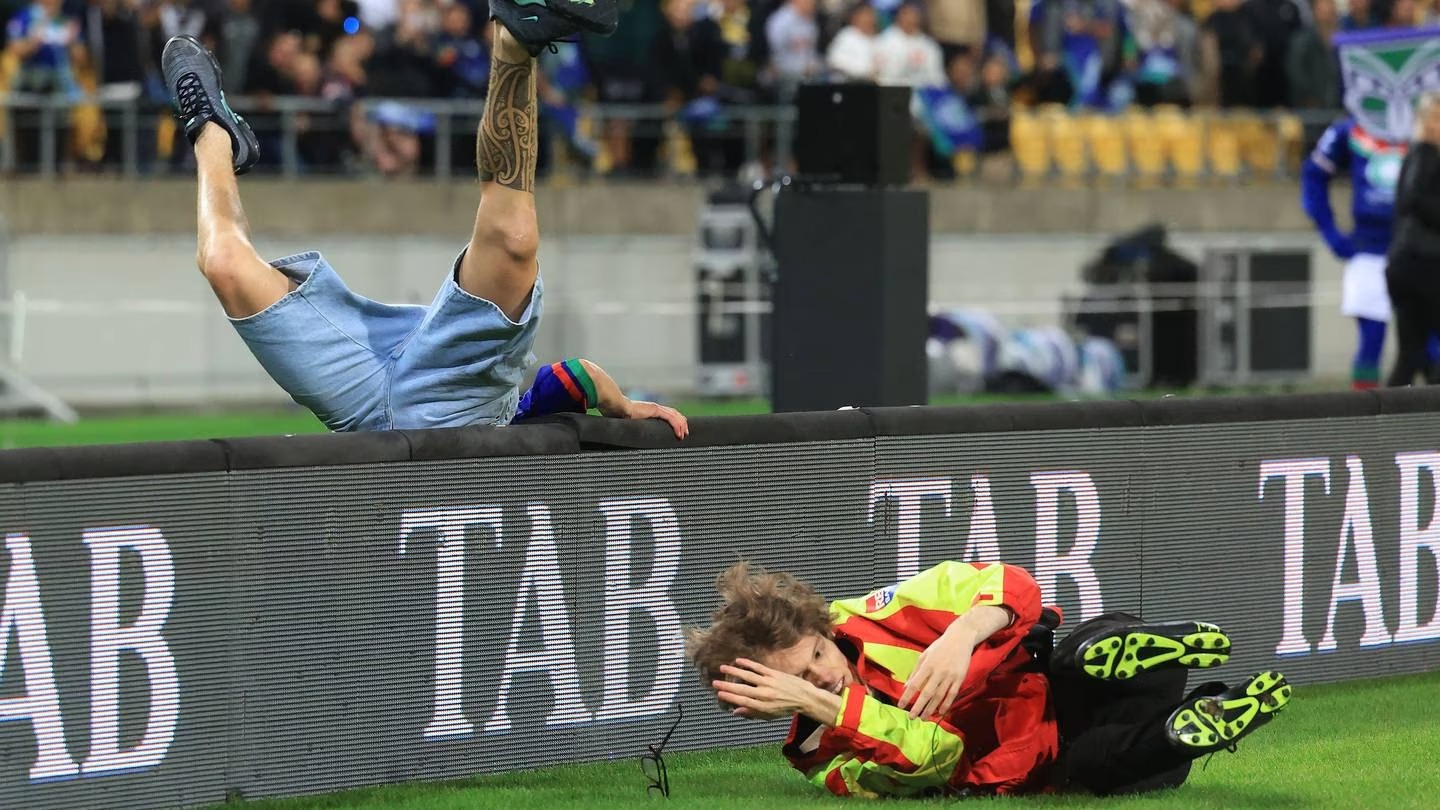 One pitch invader evades a security guard but collides heavily with advertising hoardings at Sky Stadium. Photo / Photosport