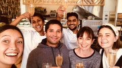 Julien and Sophie Debord (centre) with staff toasting the granting of New Zealand residency allowing them to stay in New Zealand running their Napier cafe. Photo / Supplied