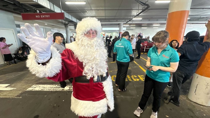 Santa in the carpark of Westfield St Luke's in Auckland after the centre was evacuated following a fire alarm. Photo / Jason Oxenham
