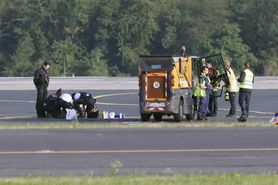 Police officers and security personnel stand on the airfield and try to detach activists of the group Last Generation who have stuck themselves to the asphalt in the airport area, in Duesseldorf, Germany, Thursday July 13, 2023. Photo / AP