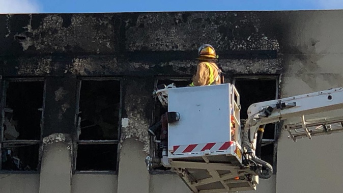 Firefighters are back examining the building from above, taking a good look through the broken windows on their way up. Photo / Georgina Cambell