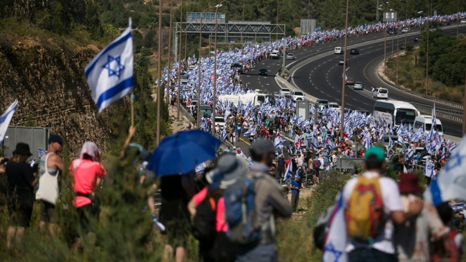 Thousands of Israelis march to Jerusalem holding the Israeli flag to protest the government's overhaul plan. Amir Levy/Getty Images