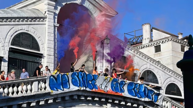 People hang a banner reading "No Space for Bezos" on the Rialto Bridge during a protest a day after the wedding ceremony of Jeff Bezos and Lauren Sanchez in Venice. Photo / AFP