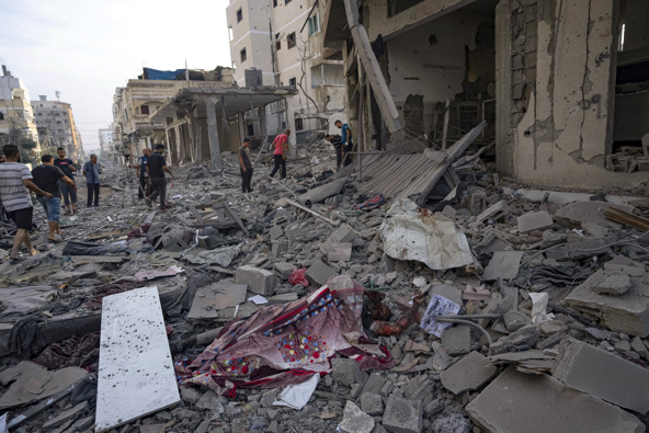 Palestinians stand among the destruction by Israeli bombing in Gaza City on Wednesday, Oct. 11, 2023. Photo / AP