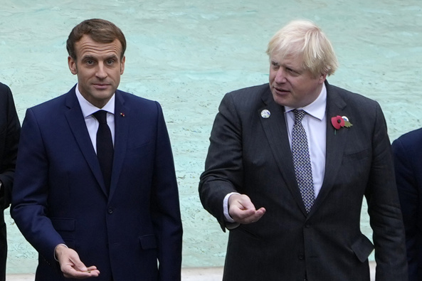 French President Emmanuel Macron, left, and British Prime Minister Boris Johnson prepare to throw a coin in the water at the Trevi Fountain during an event for the G20 summit in Rome, Sunday, Oct. 31, 2021. (Photo / AP)