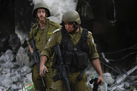 Israeli soldiers walk past houses destroyed by Hamas militants in Kibbutz Be'eri, Israel, Saturday, Oct. 14, 2023. Photo / AP