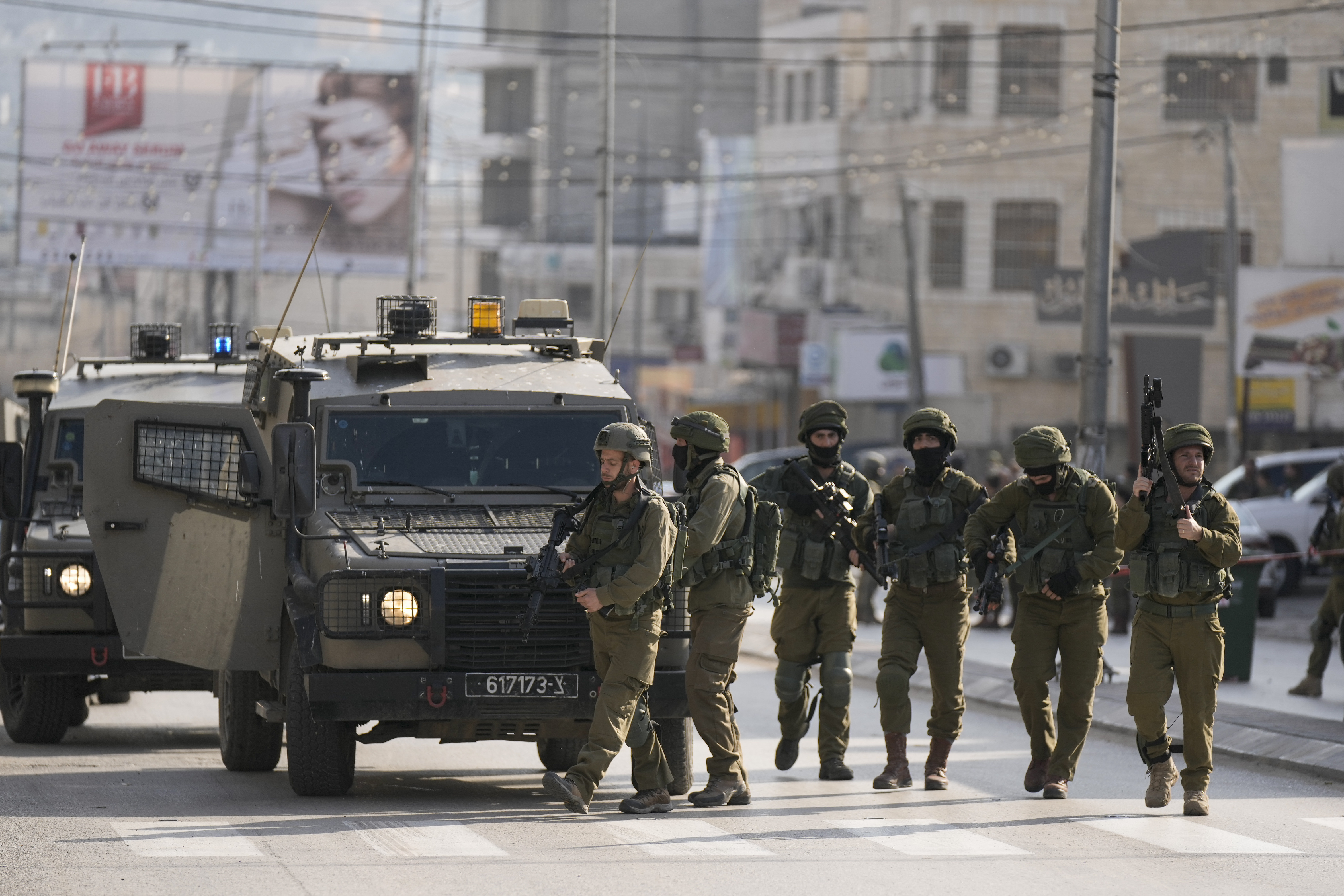 Israeli soldiers take up positions at the scene of a Palestinian shooting attack on an Israeli car at the Hawara checkpoint, near the West Bank city of Nablus, Sunday, Feb. 26, 2023. Two Israelis were killed in the shooting, Israeli officials said. Photo / AP