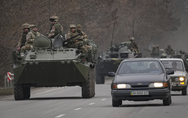 Ukrainian servicemen sit atop armored personnel carriers driving on a road in the Donetsk region, eastern Ukraine. (Photo / AP)