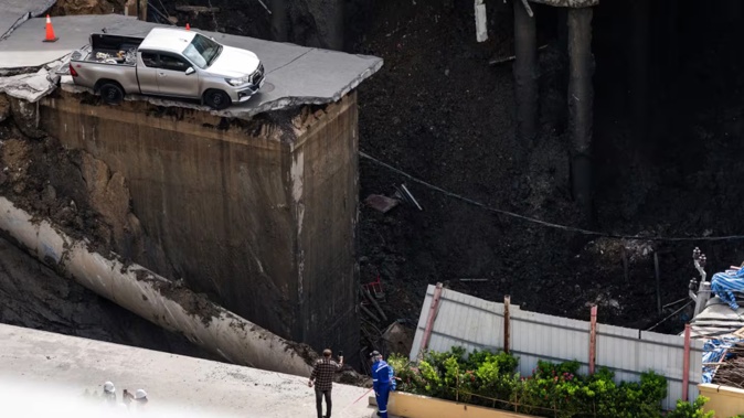 A road in Bangkok collapsed, creating a 50m hole near Vajira Hospital, causing evacuations. Photo / Chanakarn Laosarakham, AFP