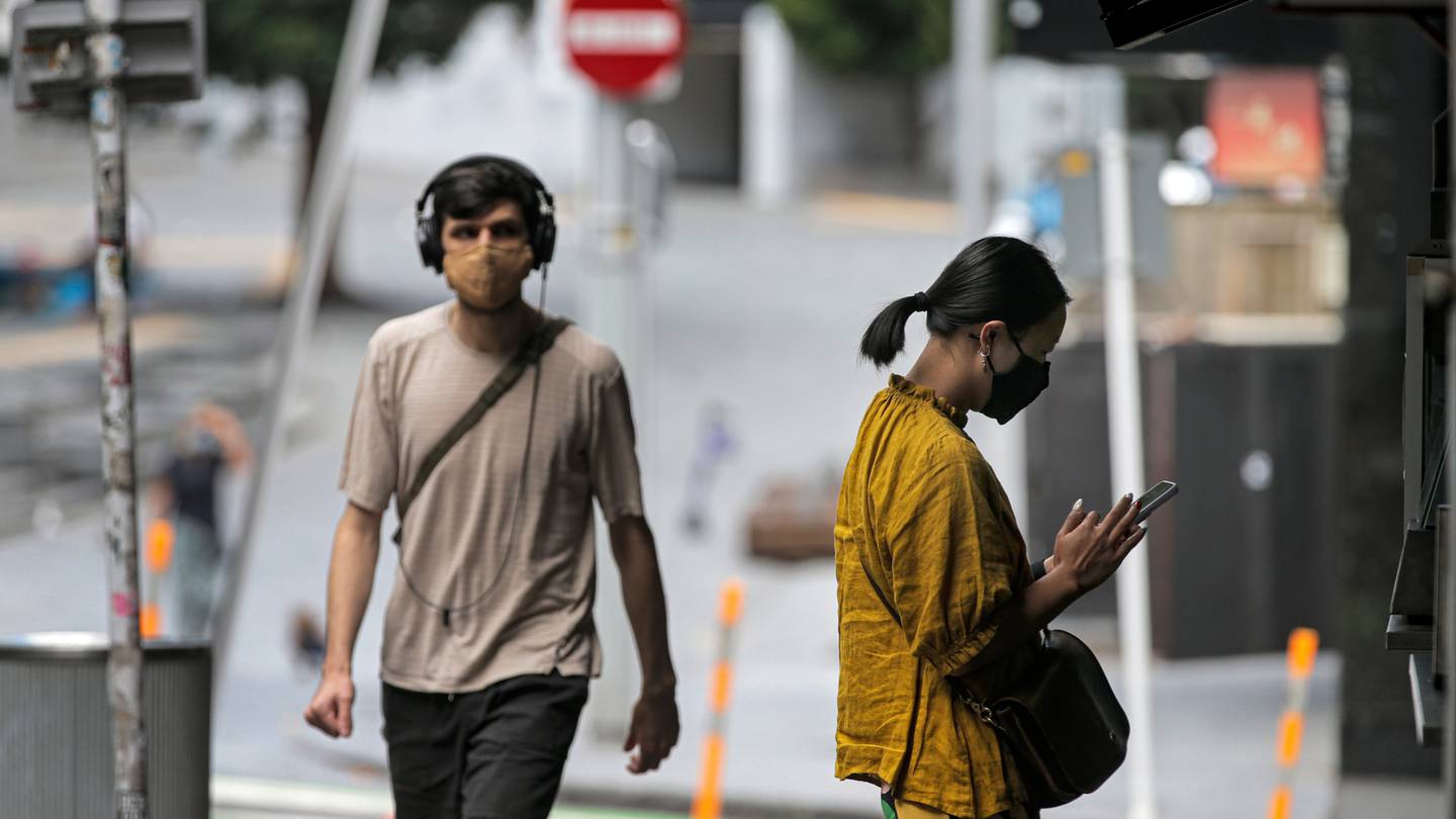 People wearing face masks in Auckland's central city. (Photo / Alex Burton)