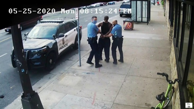 This image from video shows former Minneapolis Police Officers Thomas Lane, (left) and J. Alexander Kueng escorting George Floyd to a police vehicle outside. Photo / AP