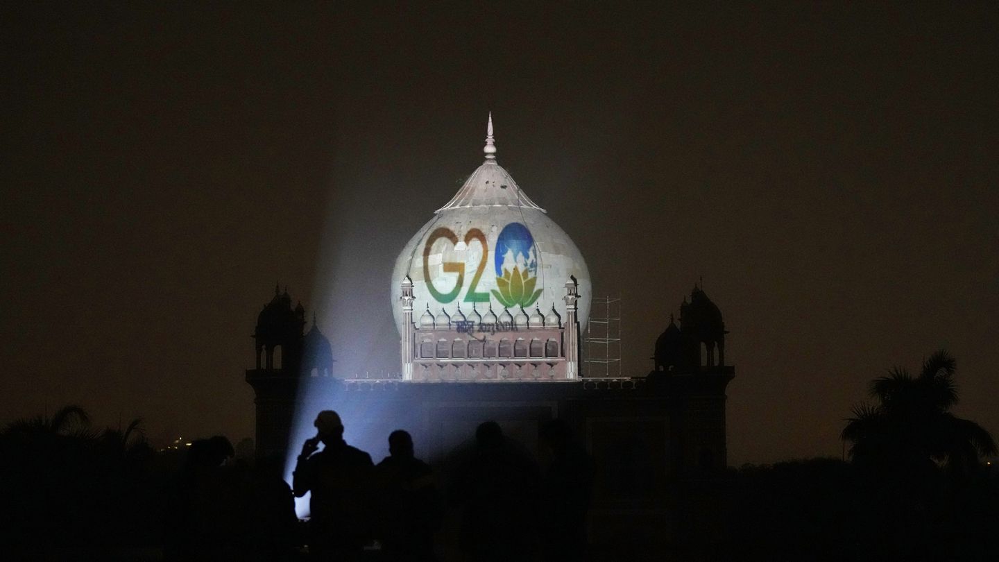 Archaeological Survey of India workers project the logo of G20 onto Safdarjung's tomb, in New Delhi. Photo / AP