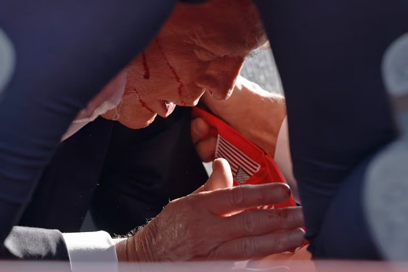 The Secret Service tend to Donald Trump on stage after the shooting. Photo / Getty Images