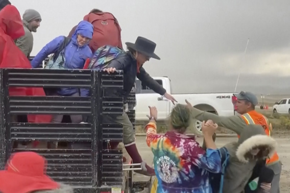 In this image from video provided by Rebecca Barger, festival goers are helped off a truck from the Burning Man festival site in Black Rock, Nev., on Monday, Sept. 4, 2023. Photo / @rebeccabargerphoto via AP