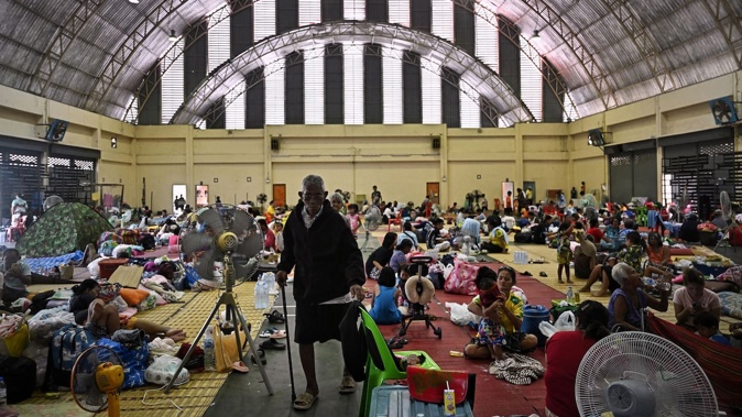 Evacuees rest as they take shelter in a gymnasium on the grounds of Surindra Rajabhat University in the Thai border province of Surin. Photo / AFP