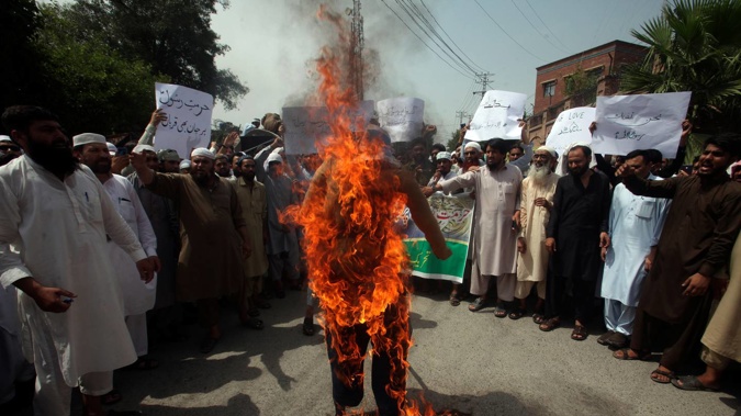 Pakistani people burn an effigy depicting India's Prime Minister Narendra Modi during a demonstration to condemn derogatory references to Islam and the Prophet Muhammad. Photo / AP