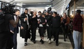 A group of supporters shield recently arrived people with links to Islamic State as they arrive at Melbourne Airport on May 07, 2026 in Melbourne, Australia. (Photo by Asanka Ratnayake/Getty Images)
