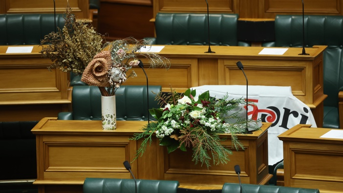 Flowers placed on Kemp’s bench, a Māori Party flag draped over her seat. Photo / Mark Mitchell