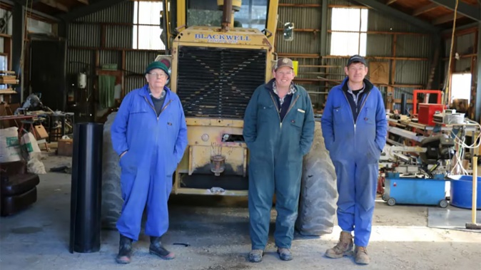 Graham, Hamish and Stuart Marr in the tractor workshop Graham's dad built in 1969. Photo / RNZ / Cosmo Kentish-Barnes