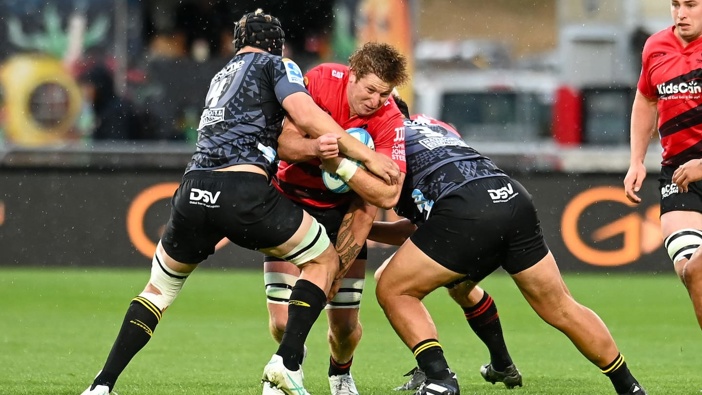 Cullen Grace of the Crusaders is tackled by the Hurricanes. Photo / Photosport