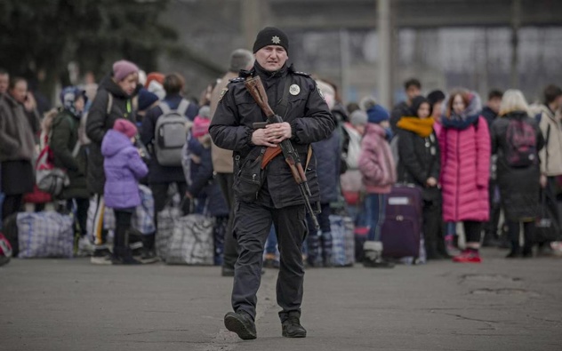 A Ukrainian policeman walks on a platform backdropped by people waiting for a Kiev bound train in Kostiantynivka, the Donetsk region, eastern Ukraine. (Photo / Supplied)