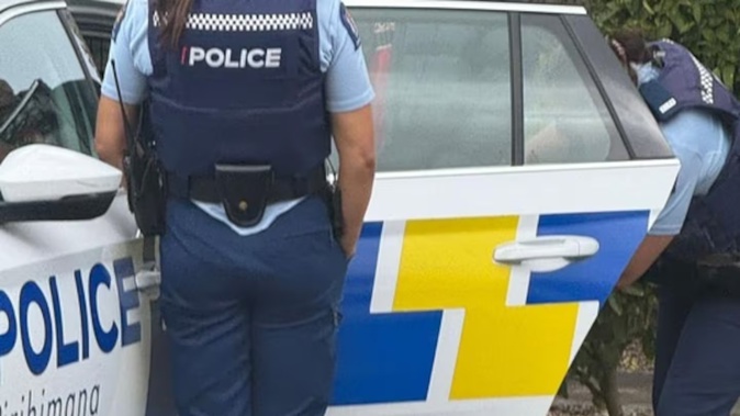 A man is taken away by police after handing himself into the Takanini Gurdwara Sri Kalgidhar Sahib on Takanini School Rd today after an alleged attack.