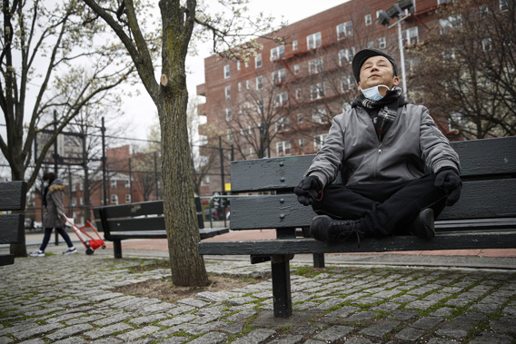 FILE - A man meditates and practices breathing exercises at a playground in New York on March 25, 2020. Research shows a daily meditation practice can reduce anxiety, improve overall health and increase social connections, among other benefits. (AP Photo/John Minchillo, File)