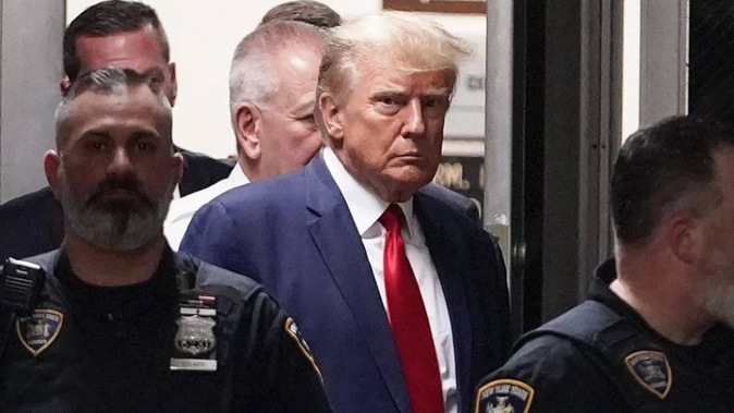 Former President Donald Trump is escorted to a courtroom. Photo / AP