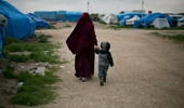 A woman walks with their son at Camp Roj in north Syria. Photo / AP
