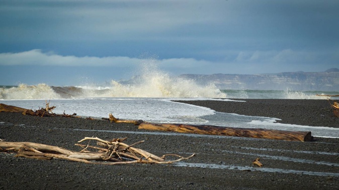 The ocean crashes on the beach at Awatoto with Cape Kidnappers nearly visible in the background. Photo / Warren Buckland
