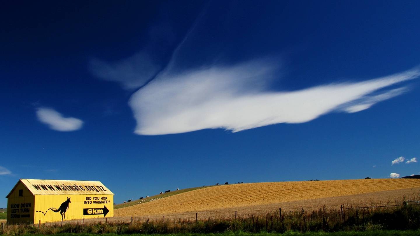 A wallaby features on a yellow shed pointing the way to Waimate.