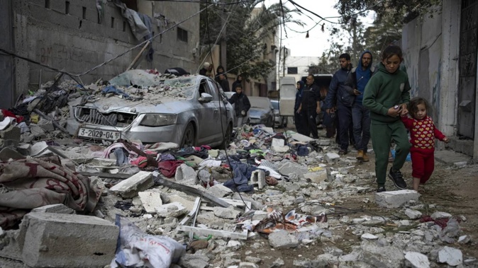 Palestinians look at the destruction after an Israeli airstrike in Rafah, Gaza Strip. Photo / AP