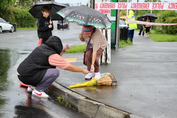 Residents lay flowers outside the Sandringham dairy. Photo / Jed Bradley