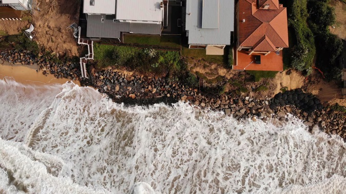 An aerial file photo taken on July 28, 2020 shows homes perched on Australia's eastern coastal town of Wamberal that are at risk of being swept away, after days of driving rain, high winds and monster swells smashed the coastline. Rising oceans caused by climate change will threaten 1.5 million Australians by 2050, a landmark report warned ahead of Australia releasing its emission targets this week. Photo / Peter Parks, AFP