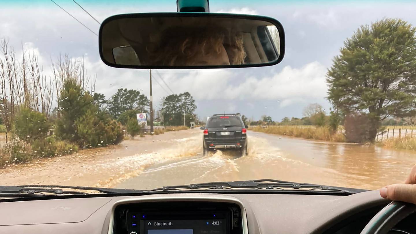 Cars negotiating a swollen river on State Highway 25 between Tairua and Whitianga. Photo / Petra Powell