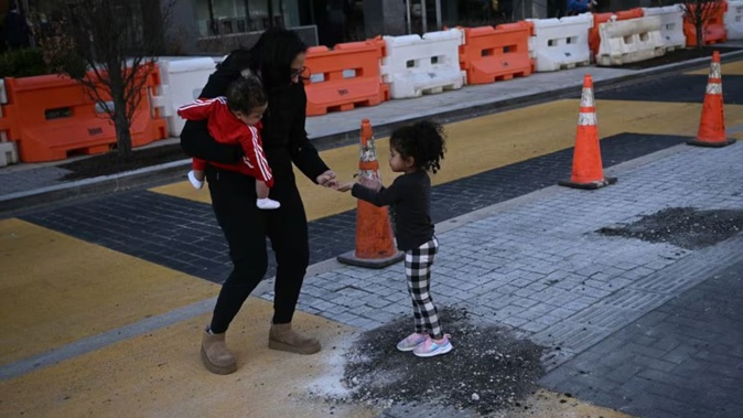 People collect pieces of the Black Lives Matter street mural as crews begin work to remove it in Washington DC.