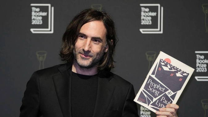 Irish author Paul Lynch poses with his book "Prophet Song" during a photocall with the six shortlisted authors for the Booker Prize 2023, in London, Thursday, Nov. 23, 2023 ahead of the award ceremony on Nov. 26 in London. (AP Photo/Kin Cheung)