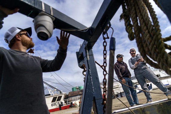 Captain Al Cottone watches the feed on a monitor from his boat, the Sabrina Maria, in Gloucester, Mass., May 11, 2022. Hager's Maine-based startup, New England Maritime Monitoring, is one of a bevy of companies seeking to help commercial vessels comply with new federal mandates aimed at protecting dwindling fish stocks. But taking the technology overseas, where the vast majority of seafood consumed in the U.S. is caught, is a steep challenge. (AP Photo/David Goldman)