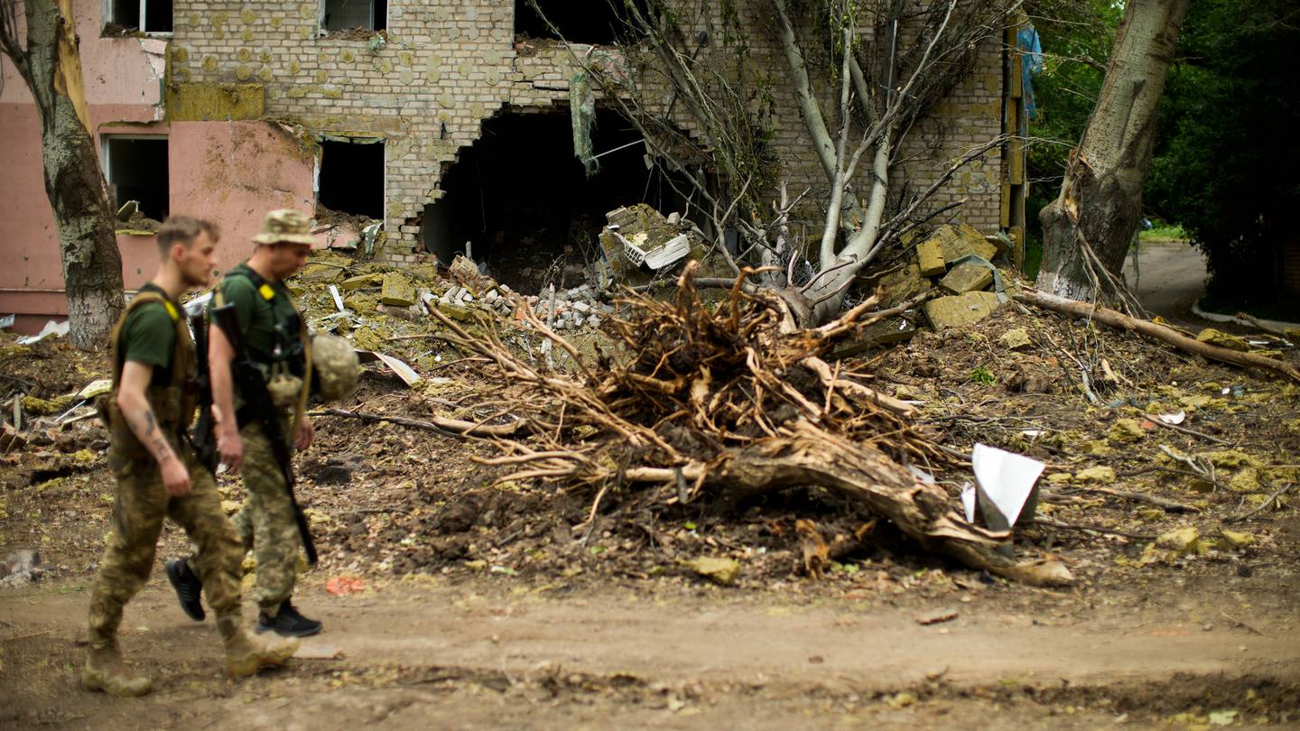 Ukrainian servicemen walk past a building heavily damaged in a Russian bombing in Bakhmut, eastern Ukraine. Photo / Francisco Seco, AP